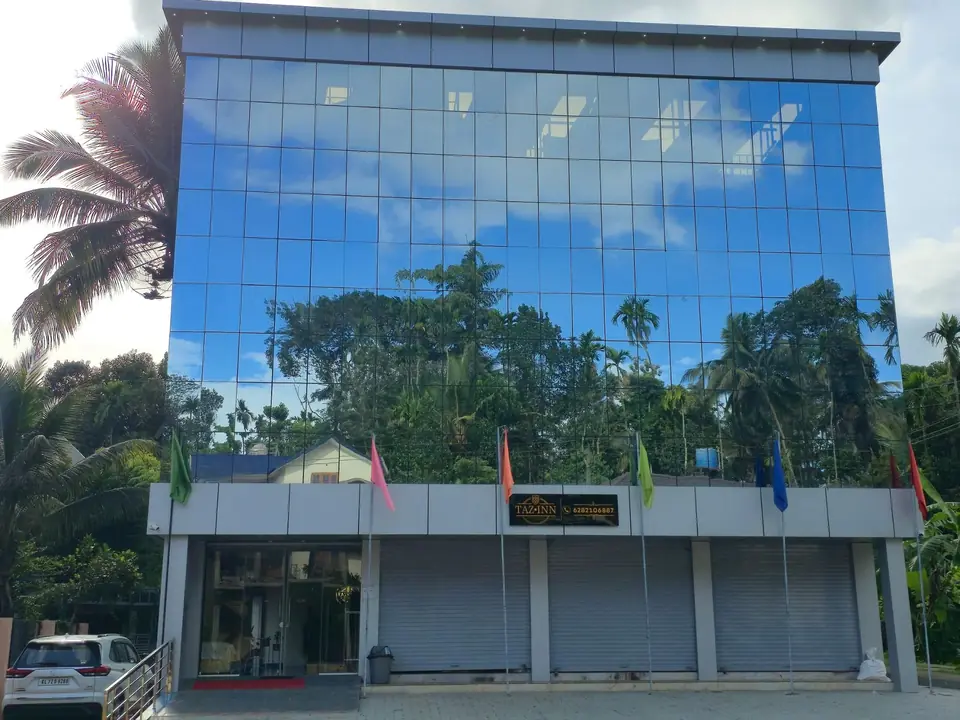 Front of Tazinn Stay with its sign and colourful flags