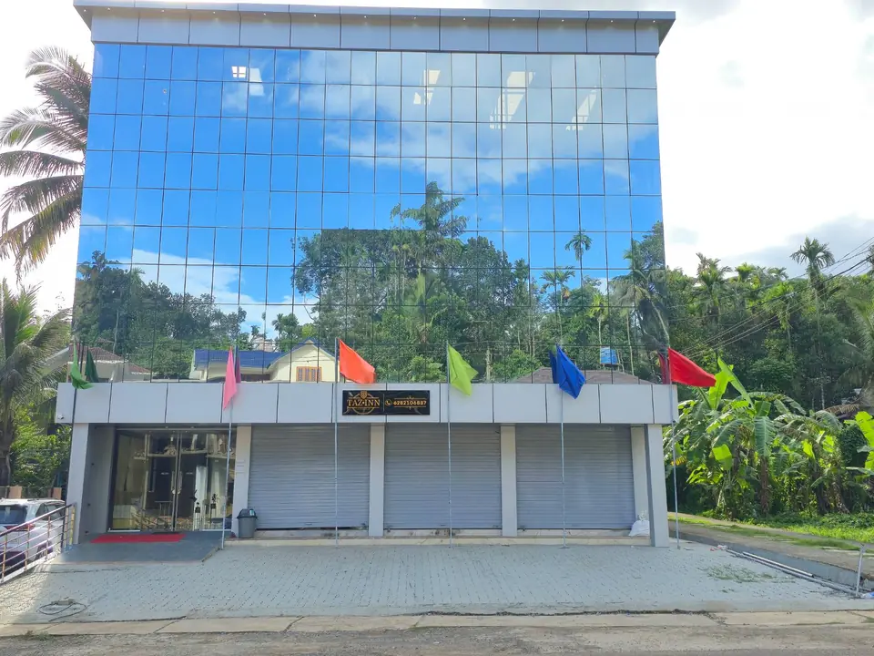 Tazinn Stay building surrounded by palm and banana trees